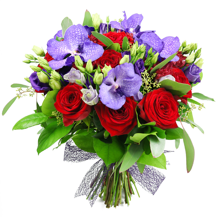 A hand-tied, luxury bouquet that pairs dramatic color with soft transition, crafted to captivate and comfort. At its heart are fully bloomed red roses, their velvety petals spiraling into a classic, timeless bloom. Framing them are lush purple Vanda orchids, their broad petals displaying delicate speckles that lend an air of exotic elegance. Intermixed are clusters of lisianthus in pale purples, some buds just beginning to unfurl, adding gentle movement and a silvery glow to the arrangement. The greenery-large glossy leaves and slender foliage-provides a rich, natural backdrop that enhances the bouquet's depth and vitality. Scattered green buds throughout reinforce the sense of freshness and growth, while tiny pale green fillers weave through the stems for subtle texture. The stems finish at the base with a dark mesh ribbon in a deep plum hue, a modern, airy bow that complements the bouquet's luxurious mood. Ideal for anniversaries, celebrations, or a generous gift, this design exudes passion and refined taste. It would sit beautifully on a dining table or entry hall in Stanmore, serving as a reminder of expert floral craft, with dependable delivery across Stanmore and nearby areas.