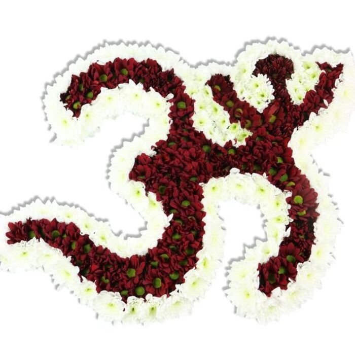 A richly textured floral rendition of the sacred Om sign sits composed against a pristine white background, its form rendered with meticulous floral craft. The symbol's core - the flowing '3'-shaped sweep, the connected S-like stroke and the crescent with its bindu above - is densely filled with small, dark red to maroon chrysanthemum-style flowers; many of these tiny blooms reveal a lime-green centre that punctuates the deep tones and lifts the composition with subtle contrast. Surrounding and defining the negative spaces of the character is a thick outline of pure white spray chrysanthemums, their compact clusters forming a sculptural frame that makes the Om unmistakable from any angle. The arrangement reads as tactile and lush: petals layered to create a soft, velvet surface with gentle undulations; the overall mass is slightly domed, suggesting careful pinning and shaping by hand. Soft studio lighting creates a faint drop shadow beneath the piece, adding depth and a sense of presence as though the emblem hovers above the page. The aroma is faintly earthy and floral, reminiscent of late-summer gardens and comforting indoor arrangements-appropriate for temple rituals, meditation sessions, or a formal memorial. As a florist who prepares floral tributes for ceremonies across Stanmore and nearby Harrow, I picture this piece placed in a quiet parish room, a community shrine near Canons Park, or as a dignified centrepiece for cultural celebrations on Stanmore High Street. Its visual honesty and reverent craftsmanship convey peace, tradition, and attentive artistry.