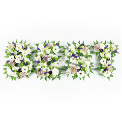An intimate and thoughtfully arranged floral lettering spells "DAD" in a calm tapestry of whites, purples and greens, photographed flat against a bright white background so every curve of each letter is immediately legible. The composition balances velvety chrysanthemums and crisp ivory gerberas-their broad faces giving strength to the letters-with softly hued pastel coffee roses that lend a gentle, vintage warmth. Sprays of violet statice and small clusters of deeper purple filler flowers weave through the design, introducing a respectful touch of colour that reads as reverence rather than display. Each letter is outlined with lively fern fronds whose serrated edges create a rhythmic frame, while compact green button chrysanthemums sit within the letters to provide texture and freshness. A subtle dark structural base holds the shapes, visible only in shadowed seams, ensuring the lettering remains exact and dignified without detracting from the blooms.

As a local Stanmore arrangement, prepared at our workshop near Stanmore Broadway and often delivered to family services in the borough, this tribute carries a quiet scent of soft florals and green stems-comforting and understated. The mix of textures, from the plush petals to the crisp greenery, reads like an embrace: familiar, steady, and consoling. Whether placed beside a memorial photograph at a chapel near Canons Park or on a service table at a private home, this DAD tribute is designed to express gratitude, sorrow and enduring affection. Flower Delivery Stanmore assembles such personalised pieces with careful attention to proportion and sentiment, mindful of the comfort they bring to those who mourn.