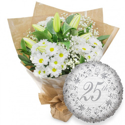 This image presents a refined 25th anniversary gift: a plentiful white bouquet set beside a silver foil balloon, all shown against a spotless white background that highlights every curve and petal. The bouquet is composed mainly of white daisy chrysanthemums, densely clustered so that their bright yellow centres appear like tiny pools of sunlight scattered through a field of white. Rising gracefully between them are long, closed white lily buds, with outer petals touched by soft green, suggesting that they will open gently over the next days, extending the life and beauty of the arrangement. Wispy strands of white baby's breath lace through the bouquet, imparting a delicate, cloud-like softness, while rich, dark green leaves curl behind, framing the flowers and adding depth. Everything is wrapped first in clear cellophane for support, then in warm, textured brown kraft paper that recalls the feel of artisan bouquets collected from local shops around Stanmore Broadway or near Bentley Priory. The base is tightly gathered and neatly tied, ready for delivery by Flower Delivery Stanmore to a doorstep overlooking Stanmore Country Park or to a restaurant hosting a family gathering. To the right of the flowers, a round metallic silver foil balloon leans gently against the bouquet. The balloon's surface carries an ornate pattern of scrolls and floral flourishes in deeper silver tones, drawing the eye inward to the central inscription "25th" written in elegant, slightly cursive script. Behind the main text, the phrase "Happy Anniversary" repeats in subtle, pale grey, adding depth without cluttering the design. The cool metallic shimmer of the balloon and the fresh white blooms together express the enduring beauty and dignity of a quarter-century of shared life in Stanmore.