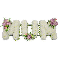 A lovingly made sympathy tribute spells "MUM" in bold, three-dimensional letters, each formed from a dense carpet of crisp white chrysanthemums that read soft and cloud-like under soft studio light. The white blooms convey purity and quiet reverence; up close you can sense the tiny, delicate textures of the spray chrysanthemum petals and a faint, clean floral scent. Three tasteful accents of muted colour lift the piece: a cluster of lavender roses with a pale pink bud rests on the upper left arm of the first "M," a matching cluster sits tucked into the hollow of the "U," and a third arrangement mirrors the first on the upper right curve of the last "M." Interspersed fern fronds and fresh green leaves add dimension and a cool, living contrast to the white mass, while a dark green ribbon-wrapped or moss-lined frame peeks out at the base, discreetly supporting the letters and keeping the silhouette crisp. Created with cemetery and chapel settings in mind, the design translates well to a church service near Bentley Priory or a graveside at a local Stanmore cemetery, arriving with calm dignity. Prepared by our Stanmore team, this composition combines traditional sympathy symbolism with careful craftsmanship, offering a serene tribute that speaks of lasting love, peaceful remembrance and the gentle kindness of a community saying farewell.