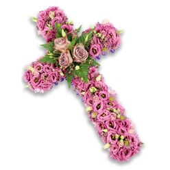 A refined floral cross arrangement is presented against a clear white background, its subtle shadow giving a sense of depth and quiet presence. The cross is lavishly adorned with a dense covering of flowers in soft pink, mauve, and gentle purple, creating a continuous, plush layer of petals that feels both comforting and dignified. At the central intersection of the arms, three fully opened roses in muted dusty-rose and light mauve shades form the emotional heart of the piece, their velvety petals spiralling outward. They are embraced by fresh green fern fronds and darker green foliage, the greenery lifting the pastel tones and adding a natural rhythm reminiscent of the tree-lined paths and open spaces around Stanmore Country Park. Extending along the vertical and horizontal arms, rows of trumpet-shaped lisianthus in varied pink tones fill the structure, their slightly ruffled petals overlapping and intertwining. Some blossoms reveal darker, more intense centres, offering a gentle contrast that draws the eye along the shape of the cross. Between the larger flowers, clusters of tiny pink and purple accents appear like soft whispers of colour, punctuated by pale cream florets with tiny yellow centres and a scattering of light green buds that promise new life. Near the edges, glimpses of slender dark-purple ribbon or underlying material reinforce the cross's outline without distracting from the floral abundance. The overall mood is one of peaceful reflection and deep respect, making this design a fitting choice for a funeral service, chapel committal, or graveside tribute in the Stanmore area. Crafted with care and sensitivity, it expresses sympathy, faith, and enduring love through its delicate yet substantial presence.
