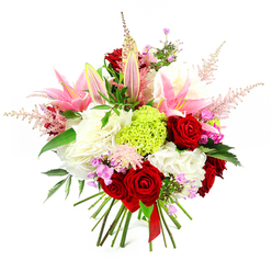 This image shows a richly detailed, hand-tied bouquet set against a bright white background, allowing every bloom to stand out with clarity, as if displayed in the window of a Stanmore florist on a sunny afternoon. In the centre, velvety crimson roses form a passionate focal point, their petals spiralling densely to create a sense of depth and intensity. Interwoven with them are pink lilies, some fully open, their long, star-shaped petals revealing soft blush interiors and delicate stamens, others remaining in sleek, green-tipped buds that suggest unfolding fragrance and beauty. Beneath these larger flowers lies a base of creamy white, ruffled blooms-resembling hydrangeas or generous carnations-adding volume and a cloud-soft cushion that brightens the entire arrangement. A vivid lime green pom of dianthus or Green Trick carnation sits prominently within the bouquet, offering bold contrast and a contemporary feel, like a refreshing burst of colour seen in the landscaped gardens around Stanmore Hill. Wispy plumes of pale pink astilbe extend upwards and outwards, introducing a feathery, romantic texture that softens the outline and brings a gentle sense of movement. Between the main blossoms, tiny clusters of fuchsia and lavender filler flowers peek out, providing playful touches of deeper pink and purple that reward closer inspection. Dark green foliage, with a subtle sheen, threads throughout the design, grounding the arrangement and emphasising the richness of the brighter tones. The stems are left exposed at the base, expertly aligned and tied with a slender deep red ribbon, signalling that this is an artisan, hand-tied bouquet rather than a vase display. Crafted with care akin to that found at Flower Delivery Stanmore, the bouquet exudes celebration and affection, making it perfect for birthdays, anniversaries, or congratulatory moments in homes and offices across Stanmore and the surrounding HA7 area.