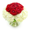 The floral design pictured here is a refined and romantic bouquet, perfectly composed against a spotless white background so that its colours and textures stand out in crisp relief. At the centre of the arrangement, and rising slightly above the rest, is a compact dome of deep red roses, around ten blooms gathered close enough that their heads form a smooth, rounded crown. Each rose displays velvety petals that curl and overlap in tight spirals, some just beginning to open to reveal their intricate hearts, like a quiet symbol of love deepening over years together. Surrounding and supporting this cluster of roses is a luxurious bed of creamy white hydrangeas, their countless small florets perched closely together to create a pillowy, cloud-like base. The hydrangeas provide volume and softness, their lightly ruffled petals catching soft highlights and gentle shadows that lend the bouquet an inviting, tactile quality. The flowers are arranged in a clear, round glass bowl vase, half-filled with clear water. Through the transparent glass, the sturdy green stems can be seen, trimmed neatly and angled in elegant lines that underscore the care taken in the design. Reflections on the glass are subtle, adding a sense of freshness without distracting from the blooms. The overall composition is harmonious and spherical, with a striking contrast between passionate red and serene white. This arrangement feels perfectly suited for an anniversary celebration in a Stanmore home, a romantic surprise awaiting someone after a visit to Canons Park, or a thoughtful delivery that quietly expresses devotion, appreciation, and lasting affection within the local community.