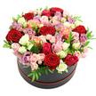 The photograph shows a sumptuous rose arrangement presented in a sleek black hat box, its base encircled by a discreet red trim that adds a refined flourish. The flowers form a rounded mound that swells just over the rim of the box, giving the impression of abundance and careful craftsmanship, like a bespoke creation made for a Stanmore celebration. The colour palette is rich yet harmonious: deep red roses draw the eye first, then yield to soft blush pinks, brighter fuchsia notes, satin-cream and snowy-white blooms, and the sun-warmed tones of peach and coral. Scattered throughout, lavender and mauve roses bring a cool, romantic whisper to the composition. The mix of full-size roses and petite spray roses creates a varied texture, so the surface isn't flat but gently undulating. Between the petals, small, clean green leaves appear in just the right measure, adding lightness and recalling the green spaces of Stanmore Golf Club or the borders of local gardens around the Broadway. The arrangement is lit evenly, without strong shadows, so every fold of each petal is visible, from the deep centres to the pale, softened edges. The black hat box itself has a modern, understated elegance, making the colours appear even more vivid against the pure white backdrop. This image captures the essence of a luxurious rose hat box gift, ideally suited to romantic occasions, landmark birthdays, or thoughtful thank-you gestures delivered across Stanmore and its neighbouring streets, a floral centrepiece that turns everyday moments into something quietly extraordinary.
