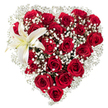 Seeing this arrangement is like reading a quiet love letter shaped in flowers: a lush, heart-shaped bouquet set against a crisp white background so every colour and texture reads clearly. Dozens of deep crimson roses-their velvety petals ranging from tight buds to fully unfurled cups-are packed closely to form the heart's bold silhouette and soft interior. Between their open throats and layered petals float tiny clusters of white baby's breath (Gypsophila), a feathery, star-like veil that cushions the roses and gives the composition airy breath and delicate contrast. In the upper-left curve a single large white lily rises with calm authority; its broad, pristine petals carry a faint cream wash toward the throat and a gentle honeyed scent, while golden-yellow stamens mark its centre and draw the eye. Soft studio light highlights the rose petals' satiny sheen and the lily's porcelain smoothness, casting subtle shadows that reveal depth and the florist's careful placement. The tactile contrasts-the velvet of petals, the papery crispness of the lily, and the whisper-soft bab y's breath-invite a gentle, close appreciation. The overall effect is romantic and refined, a classic tribute suitable for Valentine's, an anniversary, or a heartfelt apology. A local florist in Stanmore would craft this with fresh, locally sourced blooms when possible, mindful of the season and ready for delivery around Stanmore High Street, Canons Park, or the station. This floral heart speaks directly in colour and scent: a composed, skilled expression of deep affection and thoughtful intention.