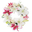 Elegant and full of meaning, this funeral wreath is a true tribute to a life celebrated in Stanmore, beautifully composed with grand white lilies and strikingly colorful fuchsia pink counterparts. The dense arrangement forms a perfect ring, symbolizing unity and eternal memory, while each large lily, with its fresh white petals and luminous green-tipped stamens, emanates calmness and respect. Intermixed throughout are magenta lilies-bold and speckled-offering uplifting contrast and depth reminiscent of the vibrant gardens and community spirit found around Stanmore Hill. Clusters of pink and white roses, ranging from tightly held buds to softly unfurling blossoms, add a gentle, romantic touch that softens the overall design. The wreath is edged with natural-looking green foliage, providing subtle texture and a nod to the open spaces of Stanmore Common. Presented against a spotless white background, the arrangement stands out in all its detailed glory, making it a dignified and heartfelt expression suitable for funeral services, memorial events, or condolence tributes delivered with care throughout Stanmore.