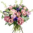 A rich, multi-layered bouquet is shown in front of a plain white background, allowing its colours and textures to take full focus. The arrangement is densely rounded and feels luxuriously full, built around large blooms that resemble garden roses and ruffled carnations in hues of dusty rose, antique pink and soft peach. Some of these flowers have opened wide, revealing intricate, velvety spirals of petals, while others remain partially closed, adding a sense of movement and freshness-as if they were just gathered from a well-tended Stanmore garden bordering the local parks. Interspersed among them are carnation-style blossoms with distinctive fringed petals that shift from bright magenta along the edges to creamy blush near the centre, giving a softly shaded effect. Deeper accents of colour come from indigo and violet-blue anemones, their dark, almost black centres forming a striking contrast against the pastel blooms, bringing a touch of contemporary flair. Rising gracefully through the bouquet are slender stems of lavender and pale pink stock, their many tiny florets creating vertical, feathery columns that suggest a sweet, powdery fragrance drifting through a nearby Stanmore townhouse. The greenery is abundant and varied: rounded, silvery-green eucalyptus leaves add cool highlights and gentle curves, while darker, broader foliage provides a strong, lush backdrop that frames the flowers beautifully. At the base, the natural green and woody stems are neatly gathered in a visible hand-tied bundle, highlighting the skilled craftsmanship behind the design. Soft, even lighting enhances every detail, from the delicate ruffles of each petal to the subtle veins in the leaves. The bouquet feels ideal for marking cherished occasions-anniversaries, thank-you gifts or thoughtful same-day deliveries across Stanmore and neighbouring areas.