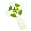 Seen from a gentle overhead angle against a clean white backdrop, this is a three-dimensional Celtic cross hand-built from fresh blooms that feels both reverent and warm. The principal body is composed of dense clusters of pure white spray chrysanthemums, their small, cushion-like heads forming a plush, cloud-soft surface across the arms and elongated shaft. Interwoven through that white field are vivid apple-green button chrysanthemums, arranged with deliberate rhythm to outline the circular ring at the cross's centre and to fill alternating sections of the horizontal arms, producing the knitted, knot-like motif emblematic of Celtic design. At the precise heart where the arms meet sits a small, intimate cluster of three fully opened golden-orange roses; their velvety petals glow like a soft ember against the cool white and fresh green and are gently hugged by a few dark green fern sprigs that add depth and a quiet, natural contrast. Soft studio lighting reveals the fine textures-the papery chrysanthemum petals, the roundness of the green buttons, the layered rose curls-and hints at a delicate floral scent: a subtle, clean sweetness with a green, almost herbal lift from the foliage. The overall composition reads as a dignified sympathy tribute or memorial piece, especially fitting for someone of Irish descent or anyone who cherished Celtic symbolism. As a Stanmore florist I imagine this fitting for a quiet farewell at a local chapel near Stanmore Common or alongside wreaths laid at a service on Stanmore Broadway; its balanced colours and careful craftsmanship convey memory, faith, and the consolation of thoughtful design.